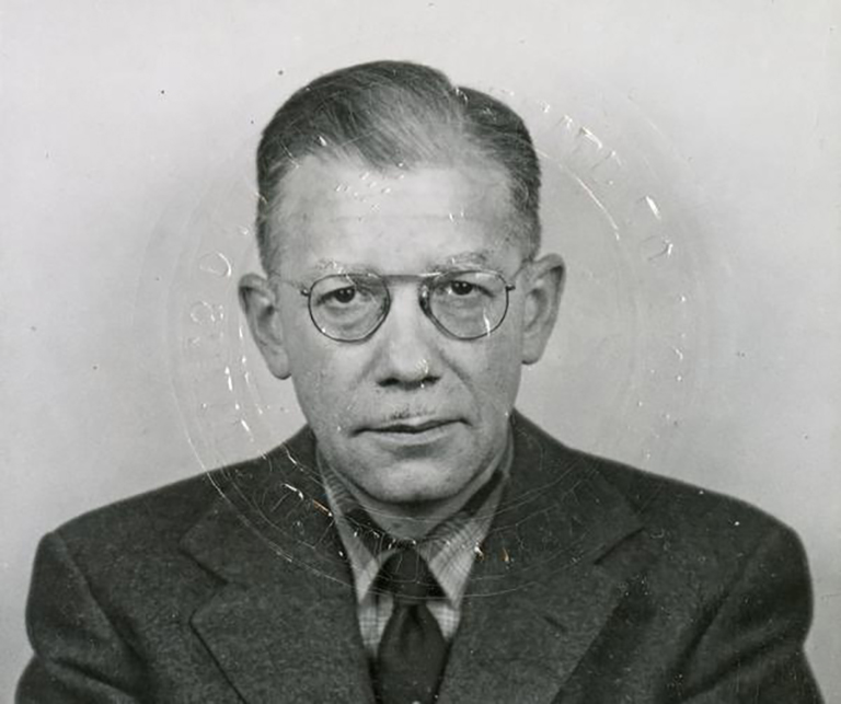 Francis Gravit, 1960 passport photo. The distortion in the image comes from the blindstamp impressed on the image. Courtesy the IU Archives.

 