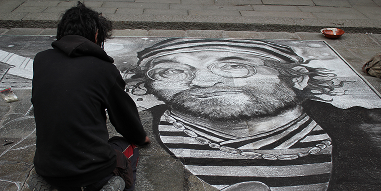 An artist works on street art in Bologna, Italy.